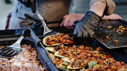 The Kitschen Koch gibt Speisen an der Theke aus The Kitschen Koch gibt Speisen an der Theke aus