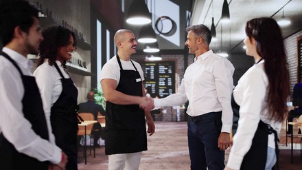 Handshake Chef vom Restaurant schüttelt einem Mitarbeiter die Hand