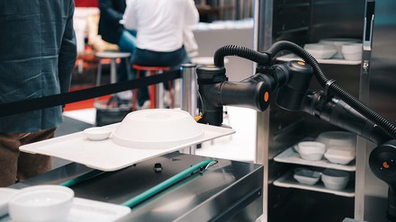 Roboterarm Roboterarm stellt Kantinentablett auf den Tresen