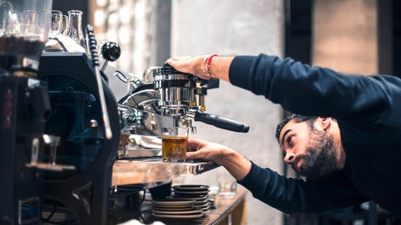 Barista an Kaffeemaschine