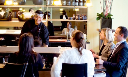 Hotelgäste sitzen vor einen japanischen Koch Hotelgäste sitzen vor einen japanischen Koch