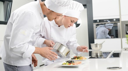 Köche beim Anrichten von Speisen Köche beim Anrichten von Speisen