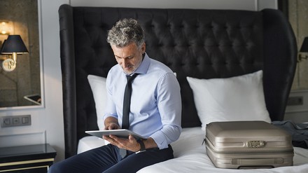 Hotelgast informiert sich mit dem Tablet über das Hotel Hotelgast informiert sich mit dem Tablet über das Hotel