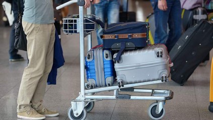 Person mit Wagen voller Gepäck