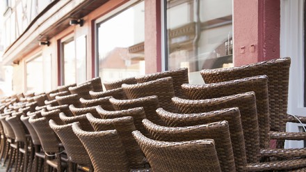 Aufgeschichtete Stühle vor einem Restaurant oder Café