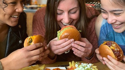 Drei Frauen essen Burger