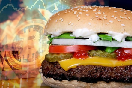 Eine Bitcion-Münze neben einem Whopper