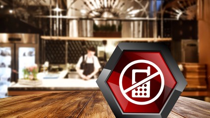 Ein Verbotsschild für Handys auf einem Restauranttisch