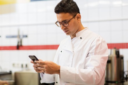 Koch schaut auf sein Handy