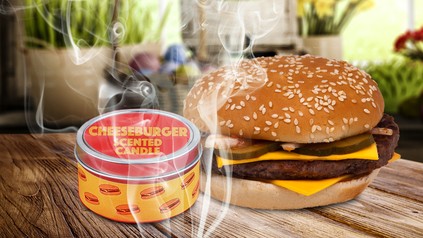 Ein Cheeseburger mit einer Duftkerze nebendran