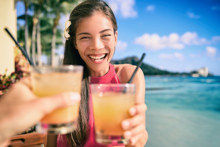 Eine Urlauberin mit einem Cocktail in der Hand