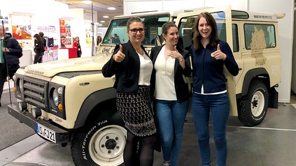 Drei junge Damen vor einem Landrover