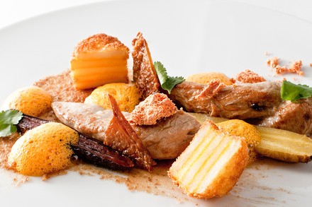 Ein gebratenes Perlhuhn auf einem Teller