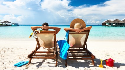 Zwei Urlauber sitzen in Liegen am Strand