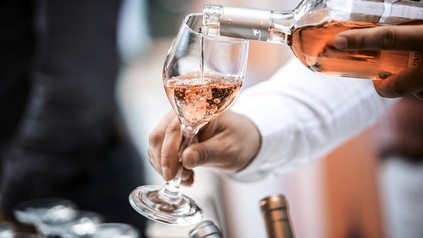 Ein ekllner schenkt ein Glas Wein ein