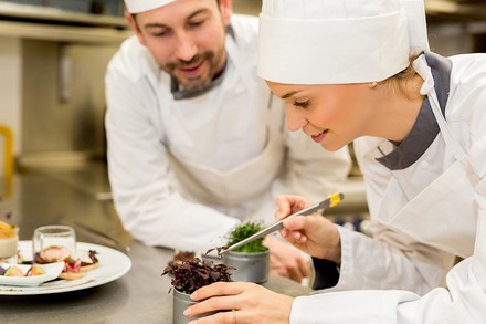 Ein Koch lernt eine junge Köchin ein