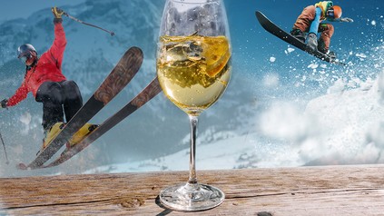 Zwei Skifahrer und im Vordergrund ein Glas Wein