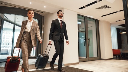 Zwei Geschäftsreisende betreten eine Hotellobby