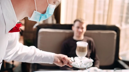 Ein Kellner mit Mundschutz