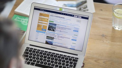 Mann an MacBook Air auf Booking.com