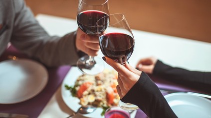 Junges Paar stößt mit Weingläsern an