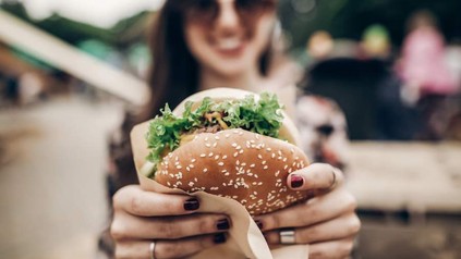 Frau hält Burger von Burger King