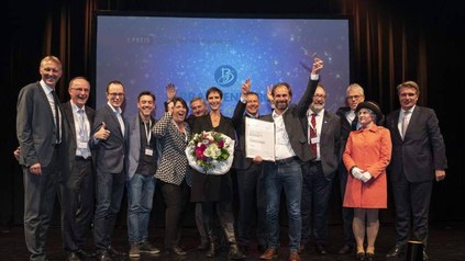 Eine Gruppe jubelnder Wettbewerbssieger auf einer Bühne