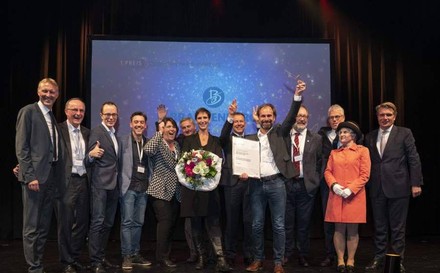 Eine Gruppe jubelnder Wettbewerbssieger auf einer Bühne