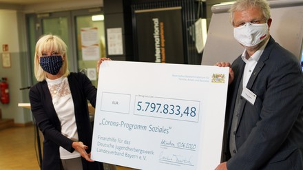 Carolina Trautner und Klaus Umbach bei einer Scheckübergabe an den Bayerischen Landesverband des Deutschen Jugendherbergswerks