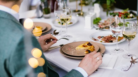 Mann sitzt an einem gedeckten Tisch im Restaurant im Rahmen einer Familienfeier