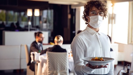 Kellner mit Essen und Maske