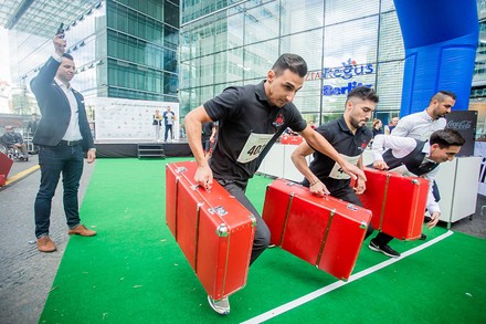 Mehrere Pagen mit Koffern auf der Startlinie einer Rennbahn