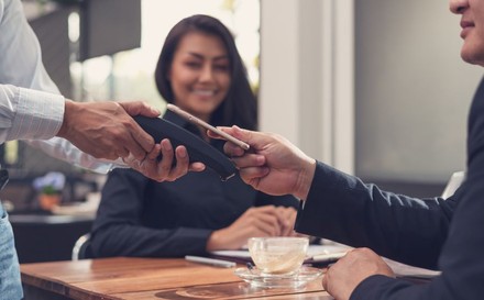 Restaurantgast bezahlt seine Rechnung via Handy