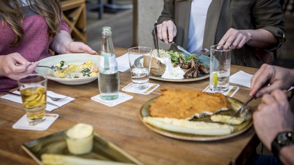 Drei Menschen essen im Restaurant