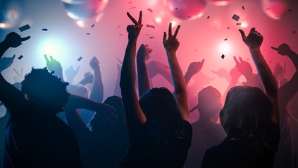 Junge Menschen tanzen ausgelassen in einem Club