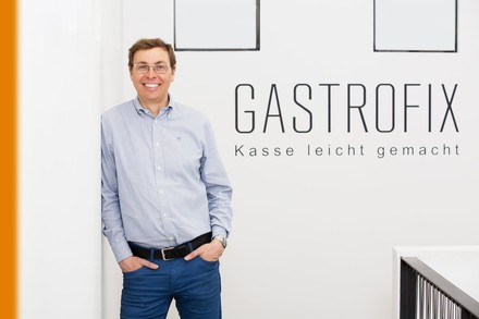 Stefan Brehm steht vor der Aufschrift Gastrofix Kasse leicht gemacht