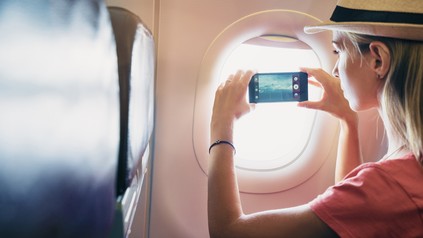 Frau fotografiert aus einem Flugzeugfenster hinaus