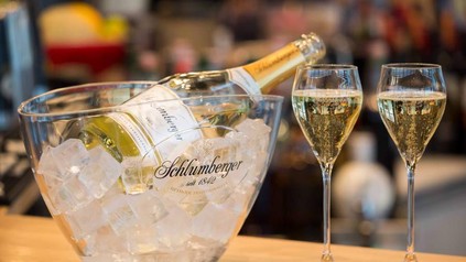 Eine Flasche Schlumberger in einer Schale mit Eis und zwei damit gefüllte Sektgläser