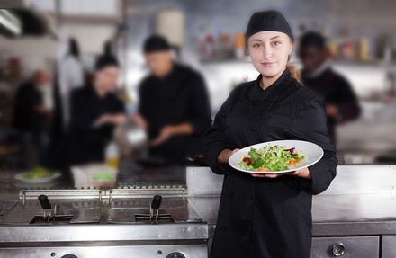 Eine Köchin in einer Großküche