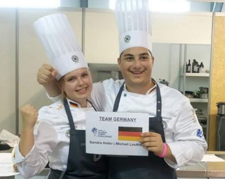 Sandra Hofer und Michail Loukid halten ein Schild auf dem Team Germany steht