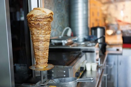 Ein Dönerimbiss mit einem Dönerspieß der noch zur Hälfte mit Fleisch bestückt ist