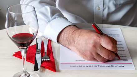 Mann füllt im Restaurant die Gästeregistrierung aus