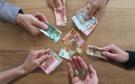 Menschen, die Geldscheine in ihren Händen halten