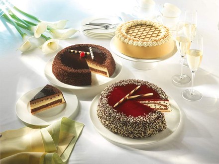Drei Torten von Coppenrath & Wiese auf einem Tisch mit mehreren Sektgläsern, Kaffeetassen und Kuchentellern
