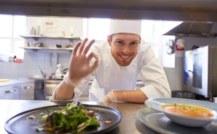 Gut gelaunter Koch zeigt OK-Zeichen
