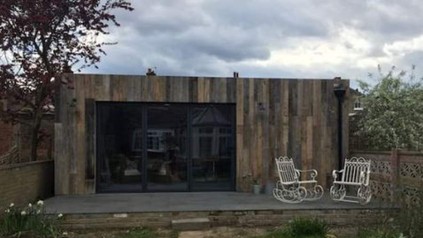 Ein kleines, einstöckiges Gebäude mit zwei Stühlen auf der Veranda