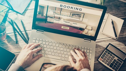 Mann sucht am Laptop nach Hotels