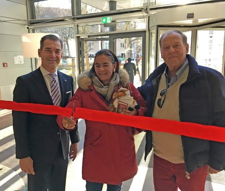 Eine Frau durchtrennt mit zwei Herren das rote Band im Steigenberger Hotel München