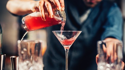 Nahaufnahme eines Barkeepers, der einen Cocktail mixt