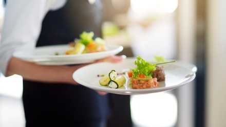 Kellner serviert Gerichte